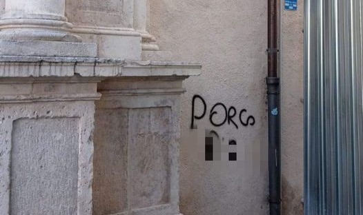 L’AQUILA: BESTEMMIA SCRITTA CON SPRAY SUL MURO DELLA BASILICA DI SAN BERNARDINO, ENNESIMA VERGOGNA